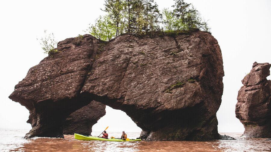 Tiny kayaks under the giant rocks