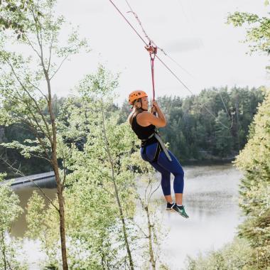 a woman ziplining over water